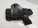 Black JPX 4 pepper gun paddle holster on a white surface