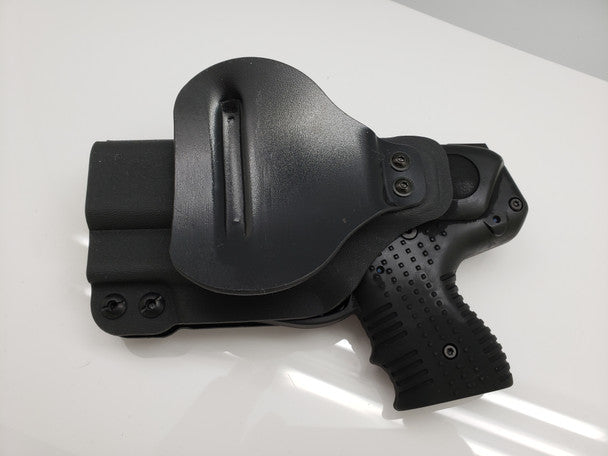 Black JPX 4 pepper gun paddle holster on a white surface