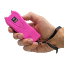 Hand holding a pink stun gun with a white background