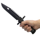 Hand holding a black survival knife.